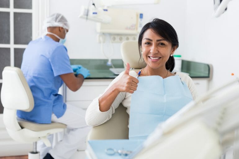 Woman Giving Thumbs Up in Dental Chair