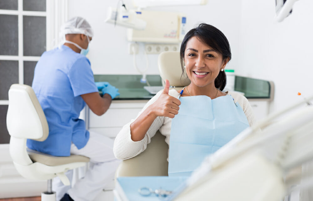 Woman Giving Thumbs Up in Dental Chair